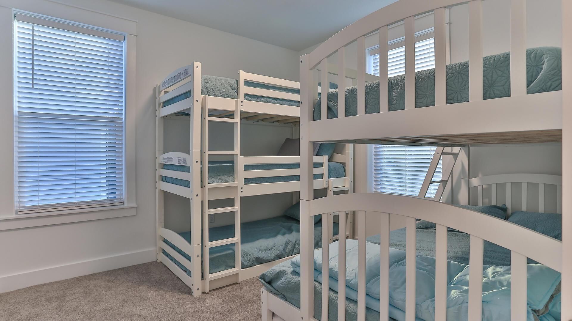 A room with bunk beds and a window with blinds.