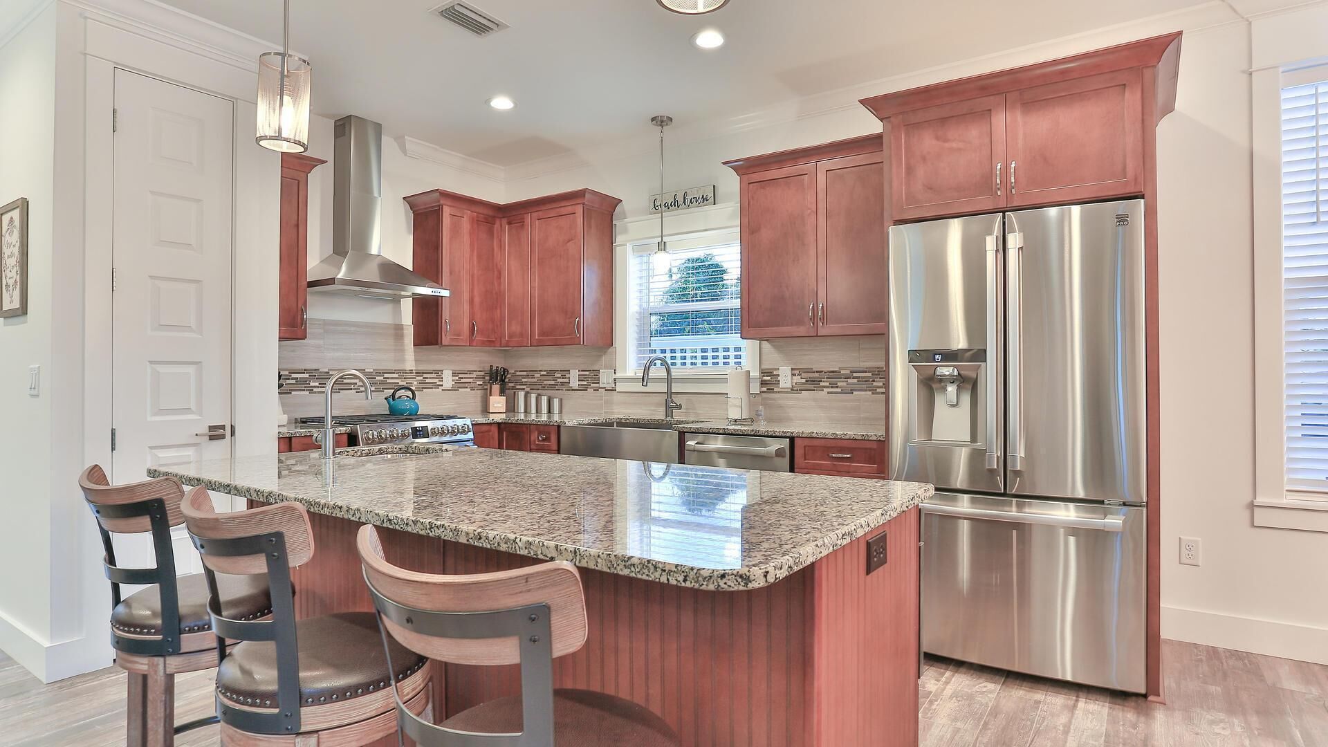 A modern kitchen with granite countertops, stainless steel appliances, and wooden cabinetry.