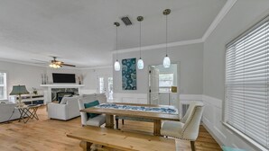Un salón amplio con una mesa de comedor de madera, un sofá y una televisión.