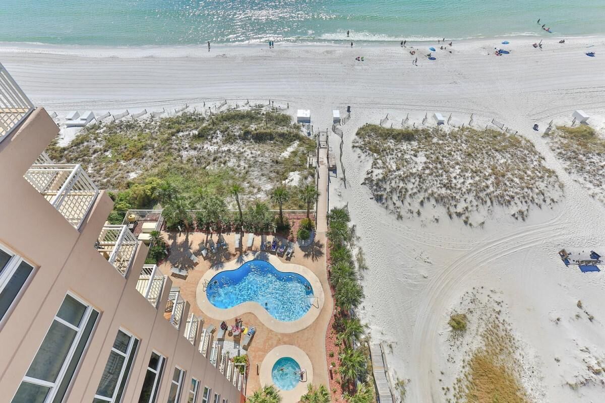 A hotel with a pool area, beach access, and a view of the ocean.