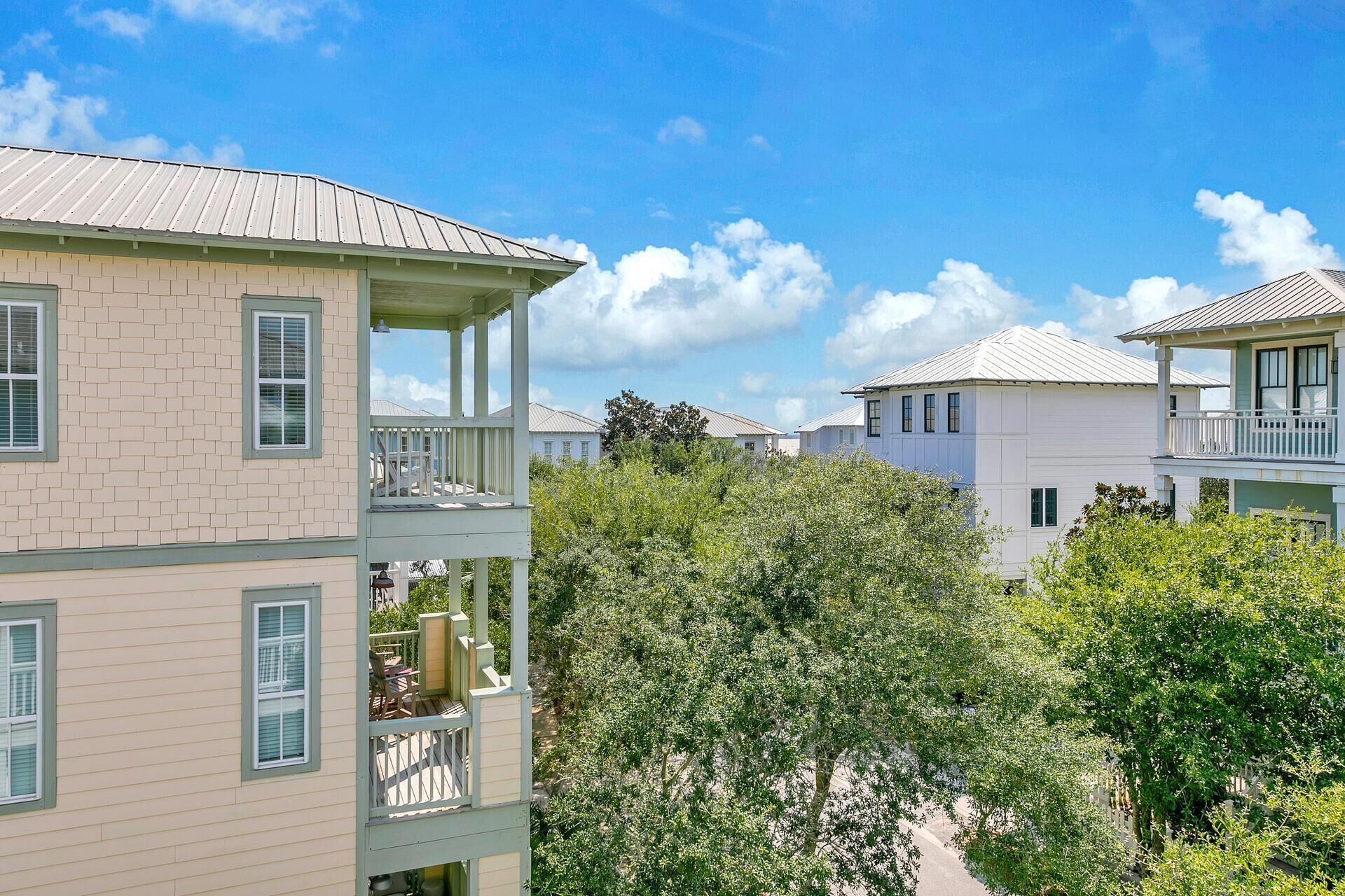 A multi-story residential building with a balcony on the second floor and a covered porch on the first floor.