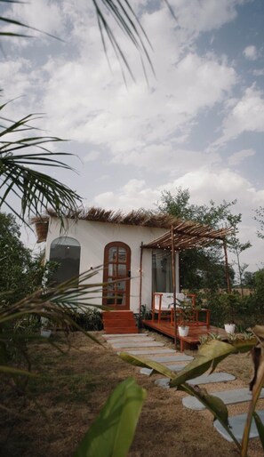 Relax on the thatched-roof patio surrounded by lush greenery and enjoy the peaceful ambiance.