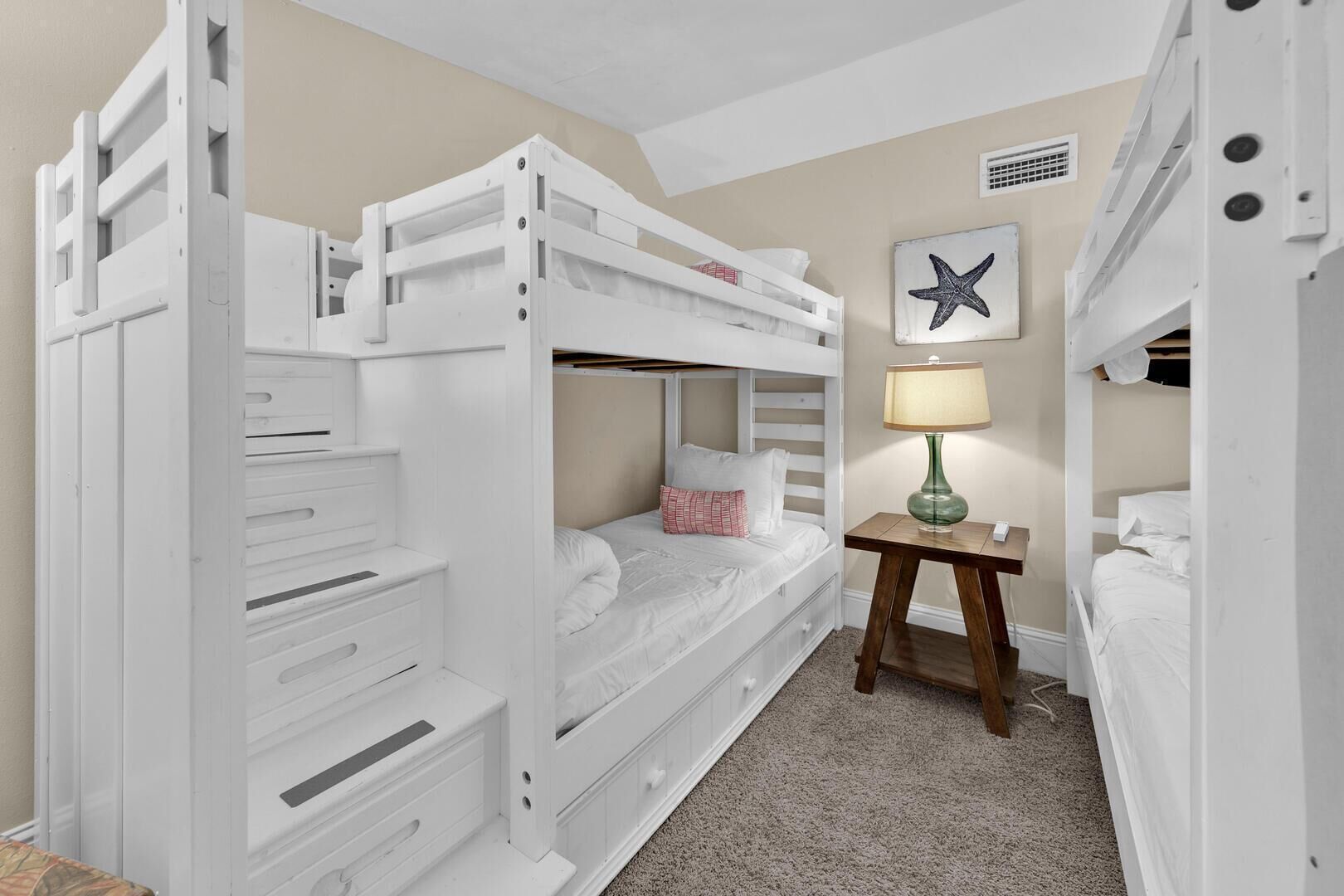 A bunk bed room with a desk and a starfish decoration.