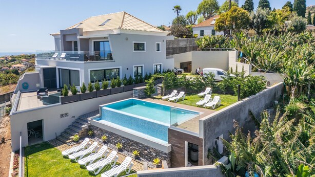 A modern two-story house with a swimming pool, sun loungers, and a view of the sea. - Sunshine Deluxe B by Madeira Sun Travel (Ponta do Sol)