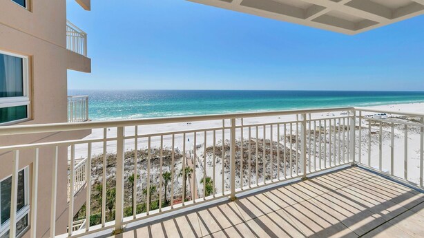 Een balkon met uitzicht op een strand en de oceaan.
