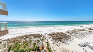Een strand met heldere lucht, zandstrand en enkele mensen.