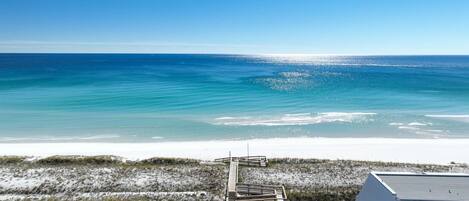 A coastal view with a sandy beach and a clear blue sky.