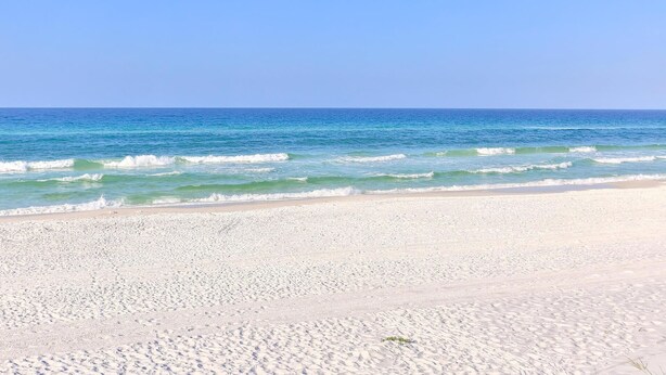 Una playa con arena blanca y agua azul cristalina.