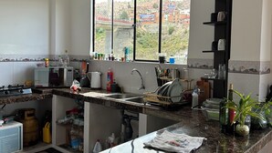 Una cocina moderna con un amplio ventanal, estufa integrada y un lavamanos.