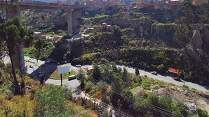 Un puente con vistas despejadas del paisaje circundante, que incluye una carretera y vegetación.