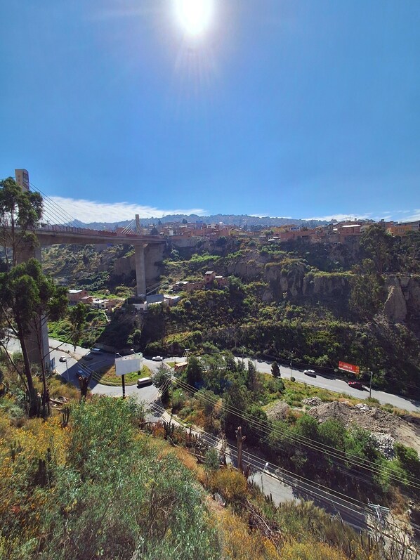 Un puente con vistas despejadas del paisaje circundante, que incluye una carretera y vegetación.