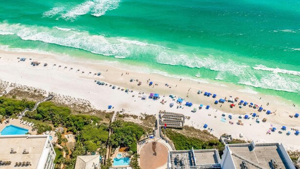An aerial view of a beach with a swimming pool, umbrellas, and beach chairs. - Kk's Beach House (Santa Rosa Beach)
