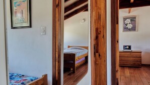 Une chambre à coucher avec un lit en bois, une commode et un tableau encadré accroché au mur.