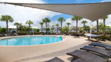 Una piscina al aire libre, sillones reclinables de piscina