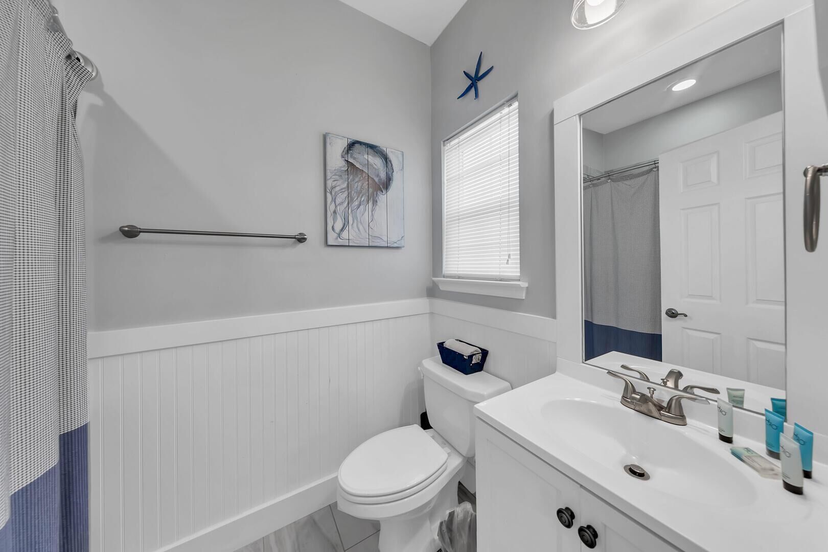 A bathroom with a toilet, bidet, sink, and a towel rack.