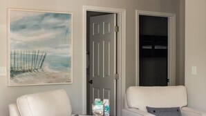 Una sala de estar con dos sillones blancos, una mesa de centro y un cuadro en la pared.