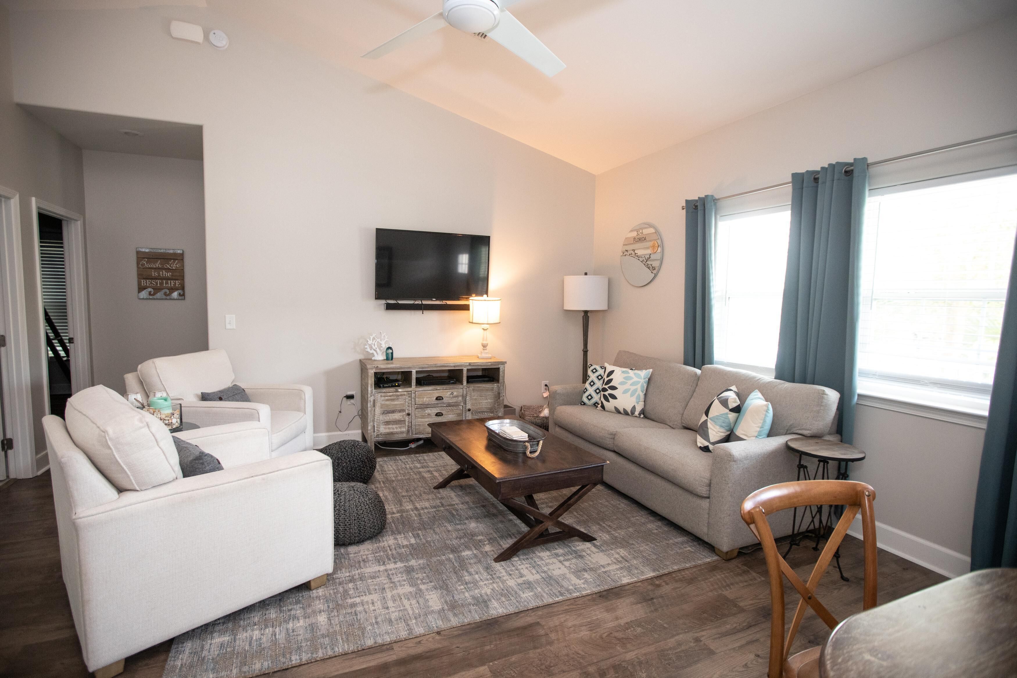 Un salon comprenant un canapé, un fauteuil, une table basse, un téléviseur et une lampe.