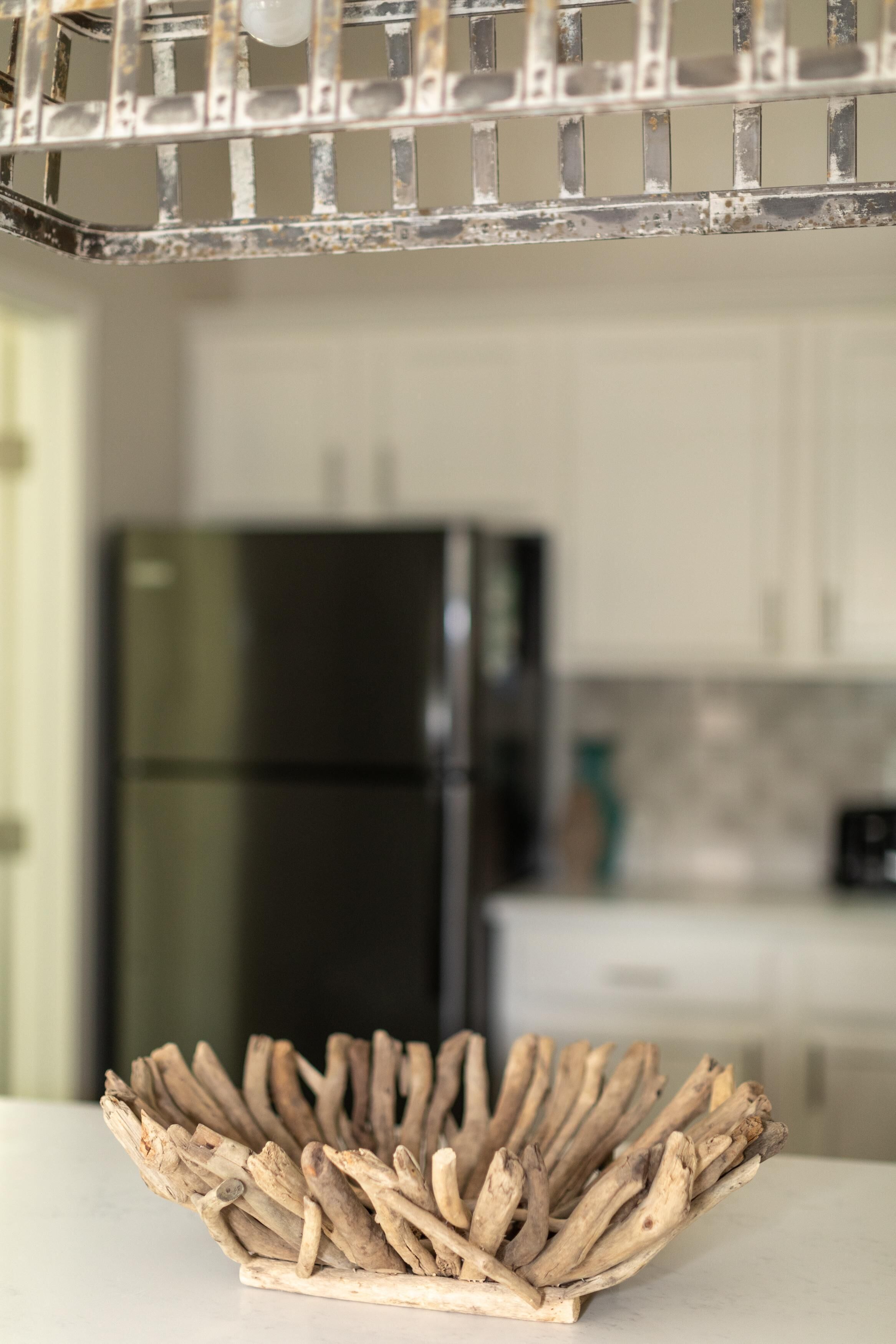 A rustic wooden bowl on a kitchen counter with a blurred background of a modern kitchen.