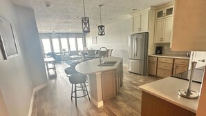 A spacious kitchen with a central island, wooden flooring, and modern appliances. - Bayside Vacation Condo Rental 4 bedrooms!! (Arnolds Park)