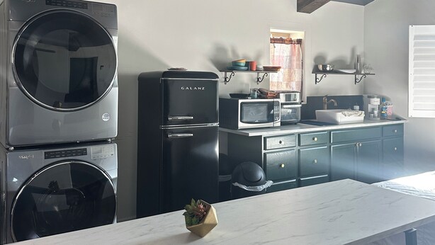 A modern kitchen with built-in appliances, a marble countertop, and exposed wooden beams. - Hidden gem. Tiny home in mural district.  (Blythe)