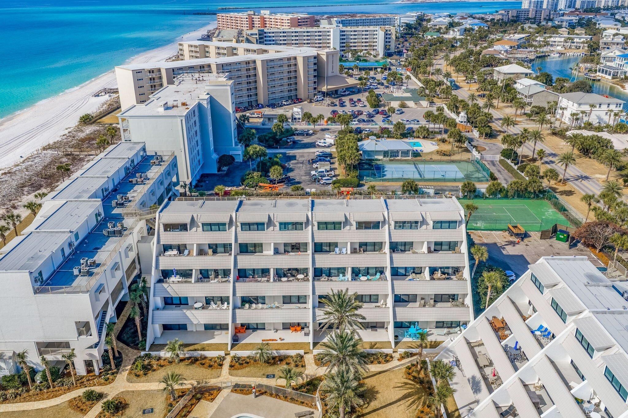 A hotel with multiple floors, a rooftop pool, and a beach view.