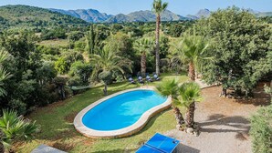 A swimming pool surrounded by palm trees and a tennis table, with mountains in the background. - Pretty Stone Finca, A/C, Private Pool, Large Grounds & Rural Views just 5mins from Old Town Pollenca (Pollença)
