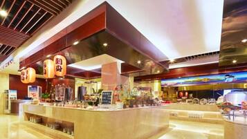 A modern hotel lobby with a central reception desk, a large digital screen, and a ceiling with a wooden slat design.