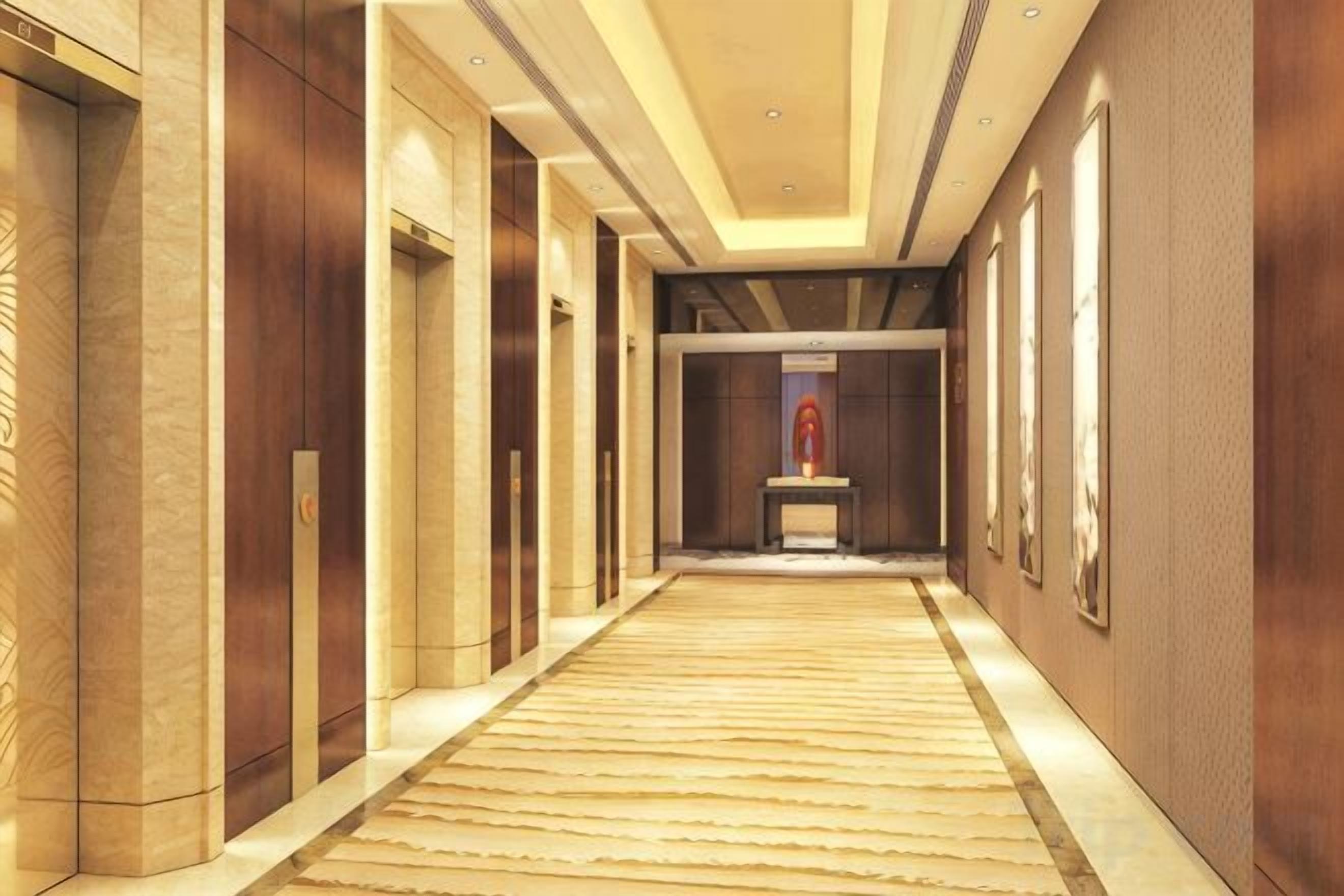 A corridor with a carpeted floor, wooden doors, and framed artwork on the walls.