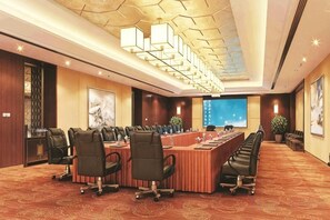 A conference room with a long table, multiple chairs, and a modern ceiling design. - Huaxi Hotel (Laixi)