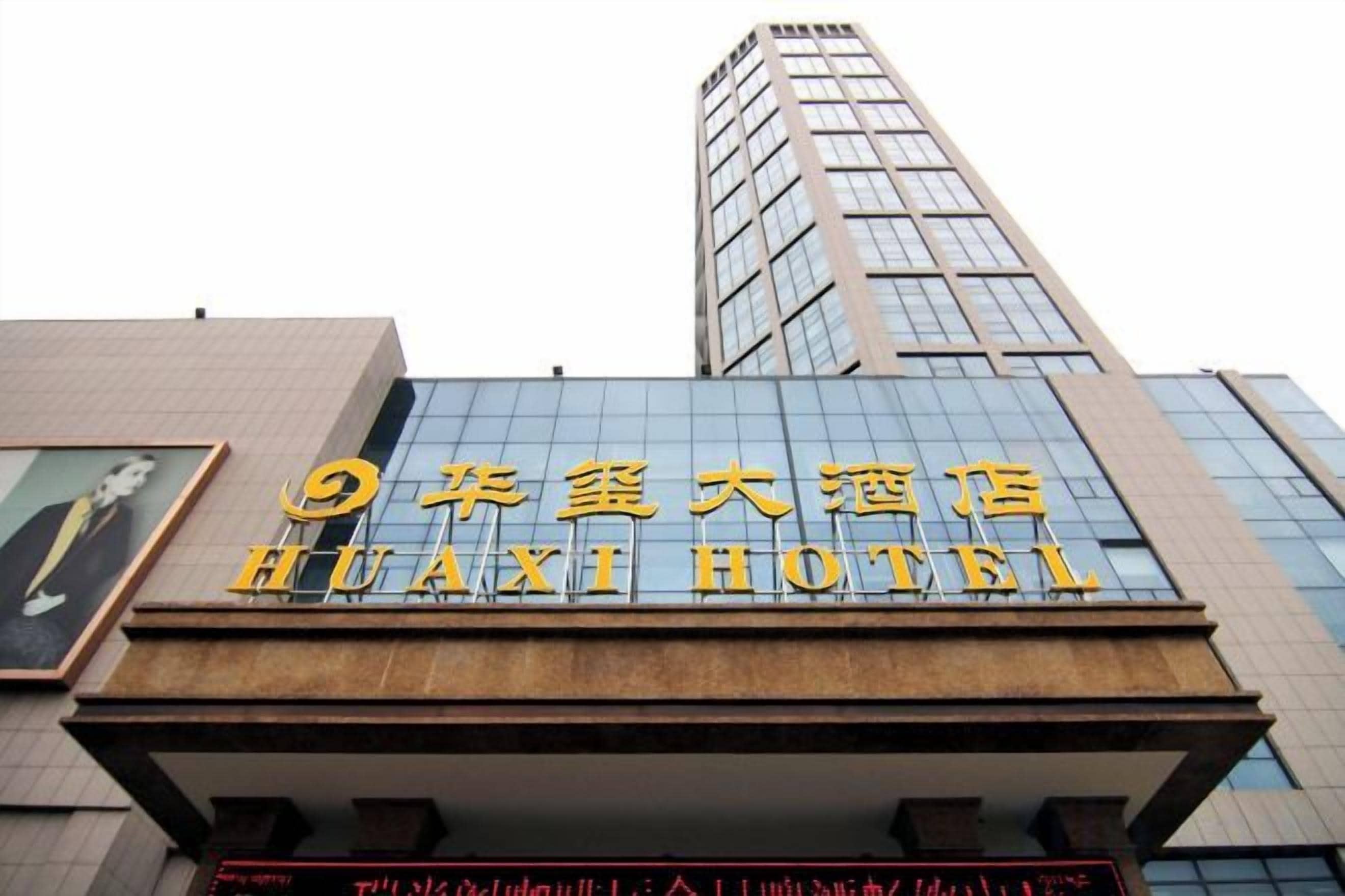A hotel sign with large golden letters and a modern building facade.