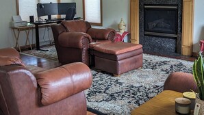 A living room with a fireplace, leather sofas, a wooden coffee table, and a computer desk. -   LARGE HOME 30 mi TO LAMBEAU FIELD GREEN BAY AND ONLY 25 mi to EAA OSHKOSH (Appleton)