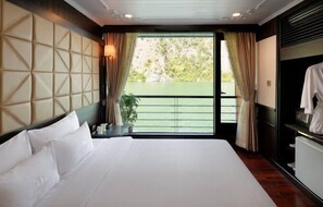 A hotel room with a large bed, a view of greenery through a sliding door, and a wardrobe with a mirror. - Pelican Classic Cruise (Tuan Chau)