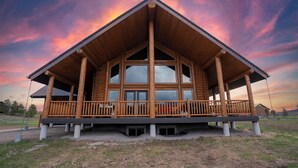 A wooden cabin with a large porch and a covered deck area. - 35 Minutes from Yellowstone Lux Log Home with Hot Tub, Pool Table, and Firepit.  (Island Park)