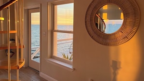 A staircase leading to a balcony with a view of the sea. - Private Waterfront Beach House with Fire-pit (Ocean Springs)
