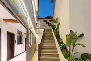 A staircase leading to a balcony with a view, surrounded by indoor plants and a modern interior design. - YUNZHINAN HOTEL (Lijiang)
