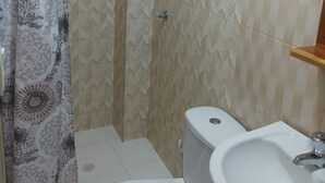 A bathroom with a shower, toilet, and sink. - Hostal Catalleya (Cartagena)