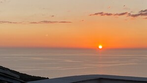 Un coucher de soleil sur une mer calme, avec un horizon dégagé.