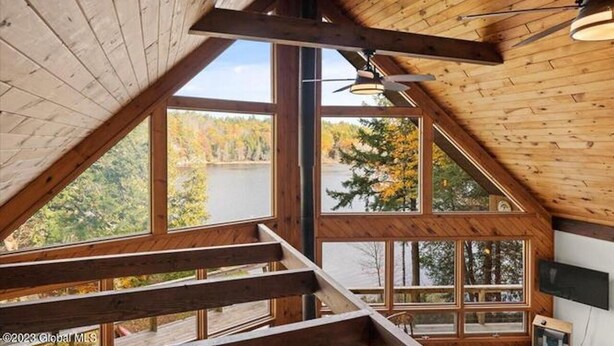 A cabin with a sloped roof, large windows, and a view of a lake. - Beautiful lakefront house on Paradox lake with tremendous views and privacy. (Paradox)