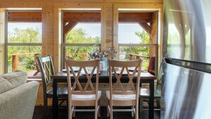 Un coin repas en bois comprenant une table, des chaises et un réfrigérateur.