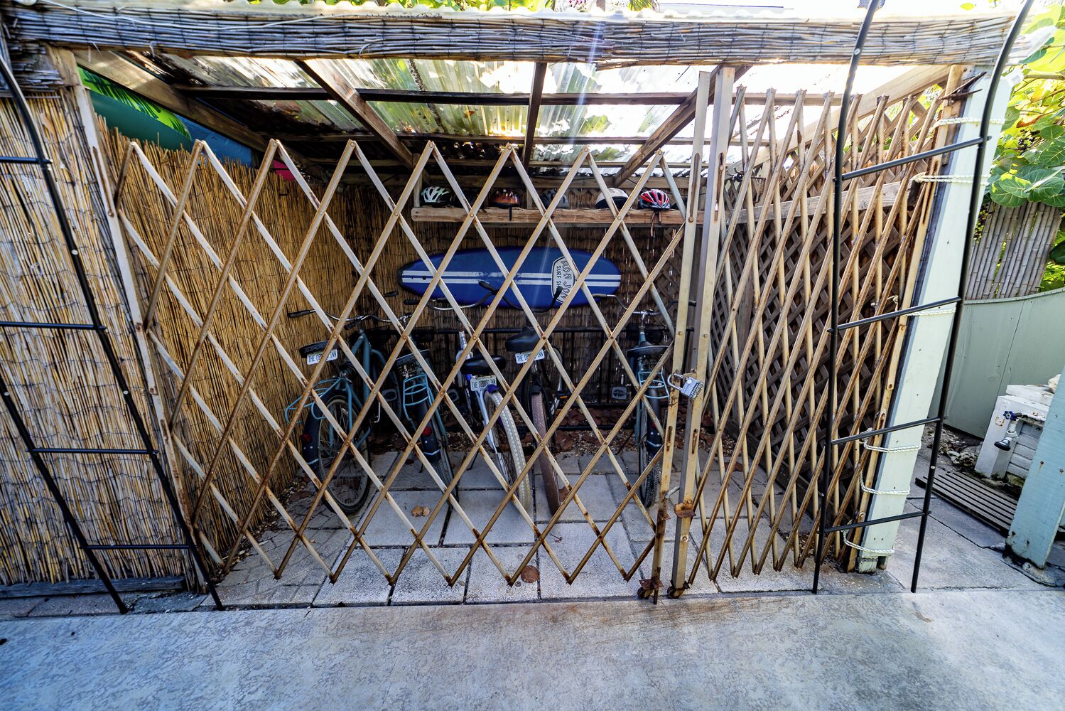 A gated area with bicycles and a blue vehicle inside.