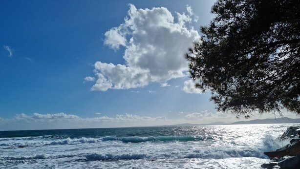 A beach with waves, a clear sky, and rocky terrain. - Les Pieds Dans L'eau ! (Saint-Raphaël)