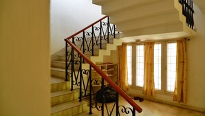 Una escalera con barandillas negras decorativas y un pasamanos de madera.