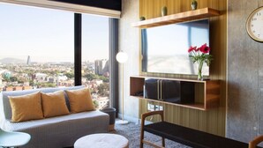 A modern living room with a sofa, ottoman, and a TV mounted on a wooden shelf. - Moderno Loft a Pasos de Reforma (Ciudad de México)
