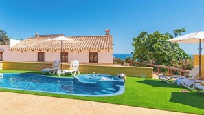A pool area with a hot tub, lounge chairs, and a view of the sea. - Casa Rural Los Aleses Vélez-Málaga by Ruralidays (Málaga)