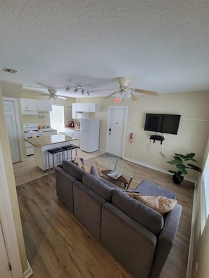 A modern apartment with a living room, kitchen, and dining area.