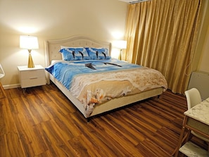 A hotel room with a bed, two bedside tables, a desk, and a chair.
