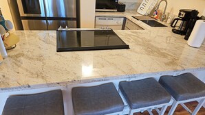 A kitchen with a large island, a microwave, a toaster, and a coffee maker. - Newly Renovated Hilo Lagoon 2 BD Condo-A/C, Pool (Hilo)