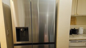A stainless steel refrigerator with a water dispenser in a kitchen setting. - Newly Renovated Hilo Lagoon 2 BD Condo-A/C, Pool (Hilo)