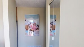 A hallway with wooden flooring, a ceiling light fixture, and a sliding glass door.