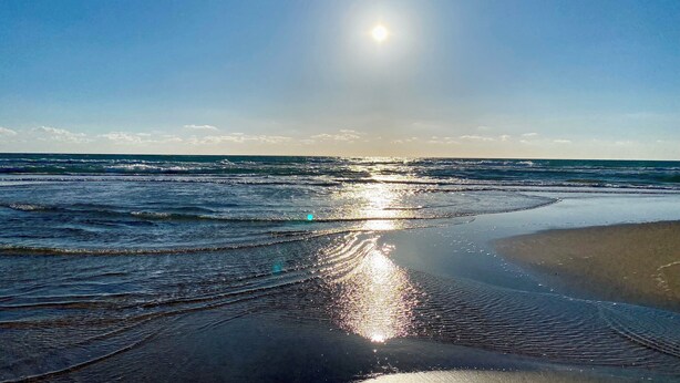 A beach with sunlight reflecting on the wet sand and waves. - Bel Appartement Moderne , Vue Océan Front de Mer, Plage, Nature, Détente (Tanger)